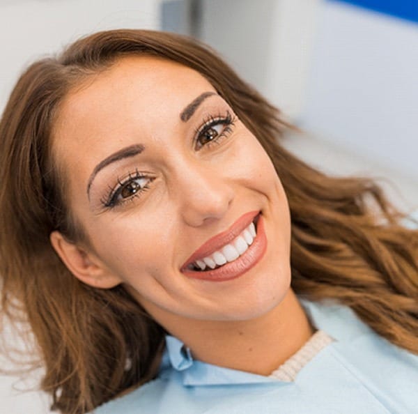 Woman smiling with straight teeth at dental appointment